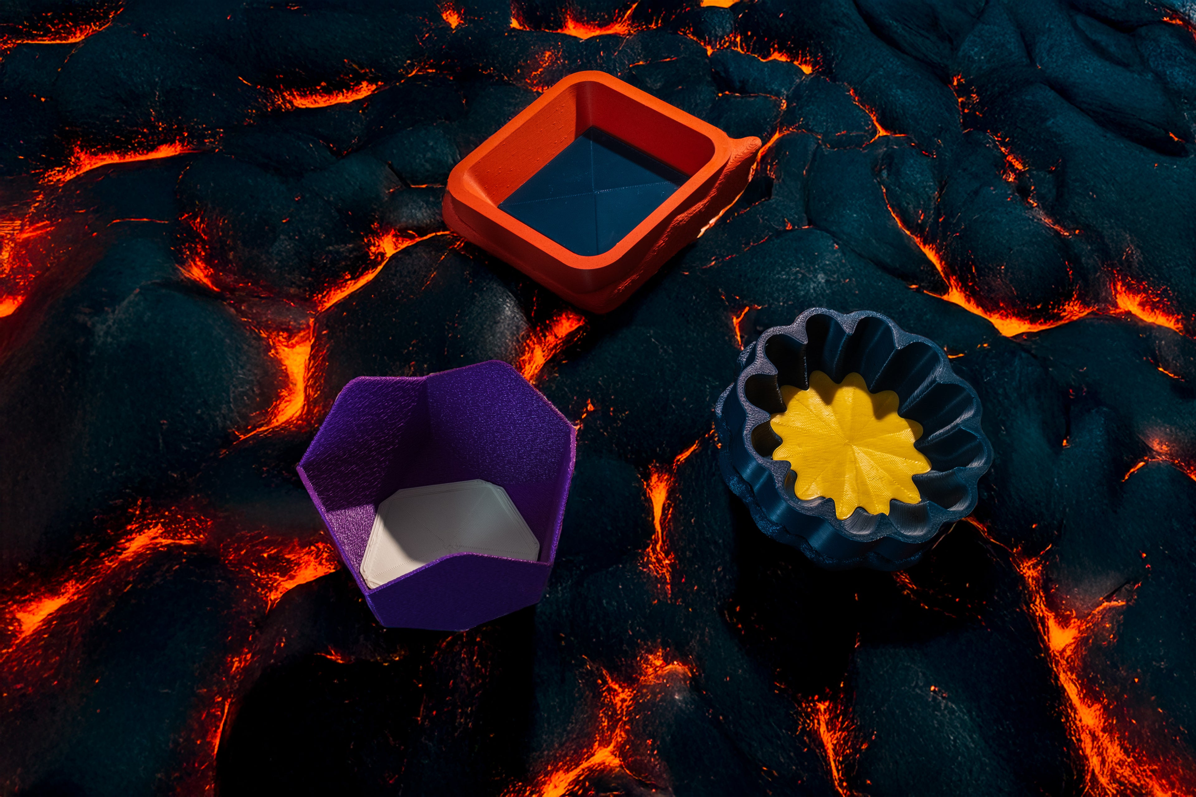 A group photo of varying geometrically shaped catchalls. There are interchangeable coasters inside of each catchall in the colors black, white, and yellow.