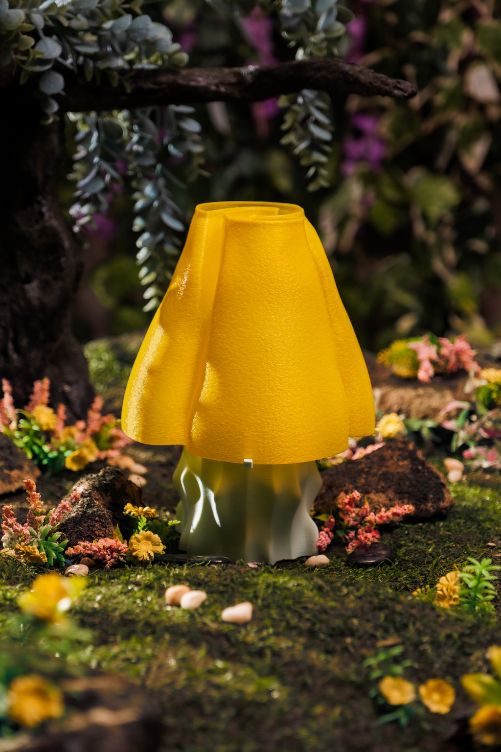 A yellow, mushroom-shaped, 3D-printed lamp on a lush forest floor.