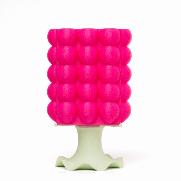 A pink, bubble-textured 3D-printed lamp with a mint green base.