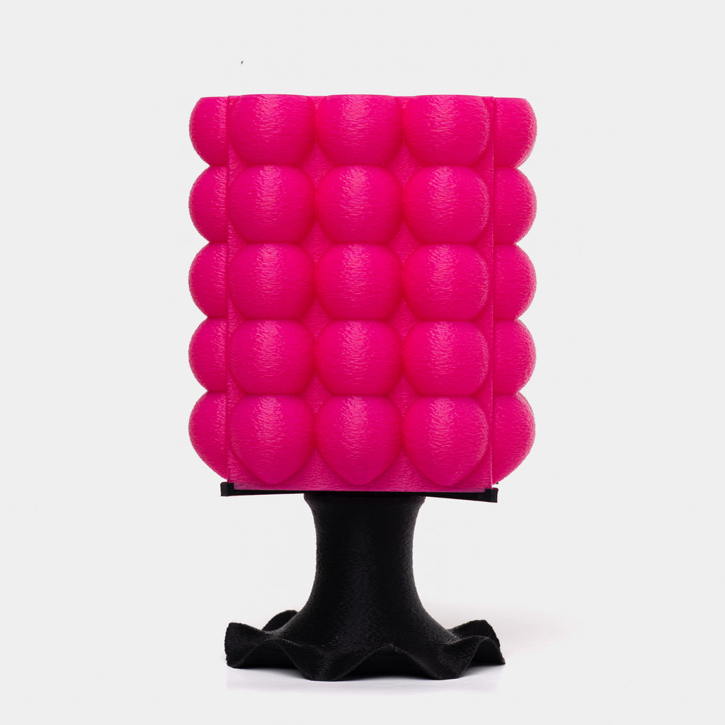 A pink, bubble-textured 3D-printed lamp with a black base.