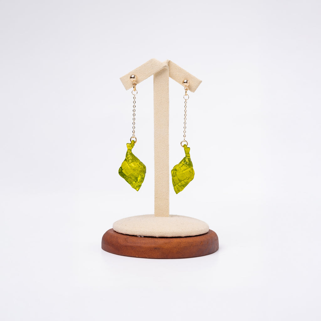 A dangling earrings set of resin-printed puso charms with a gold non-tarnish chain. The earrings is displayed on a stand.