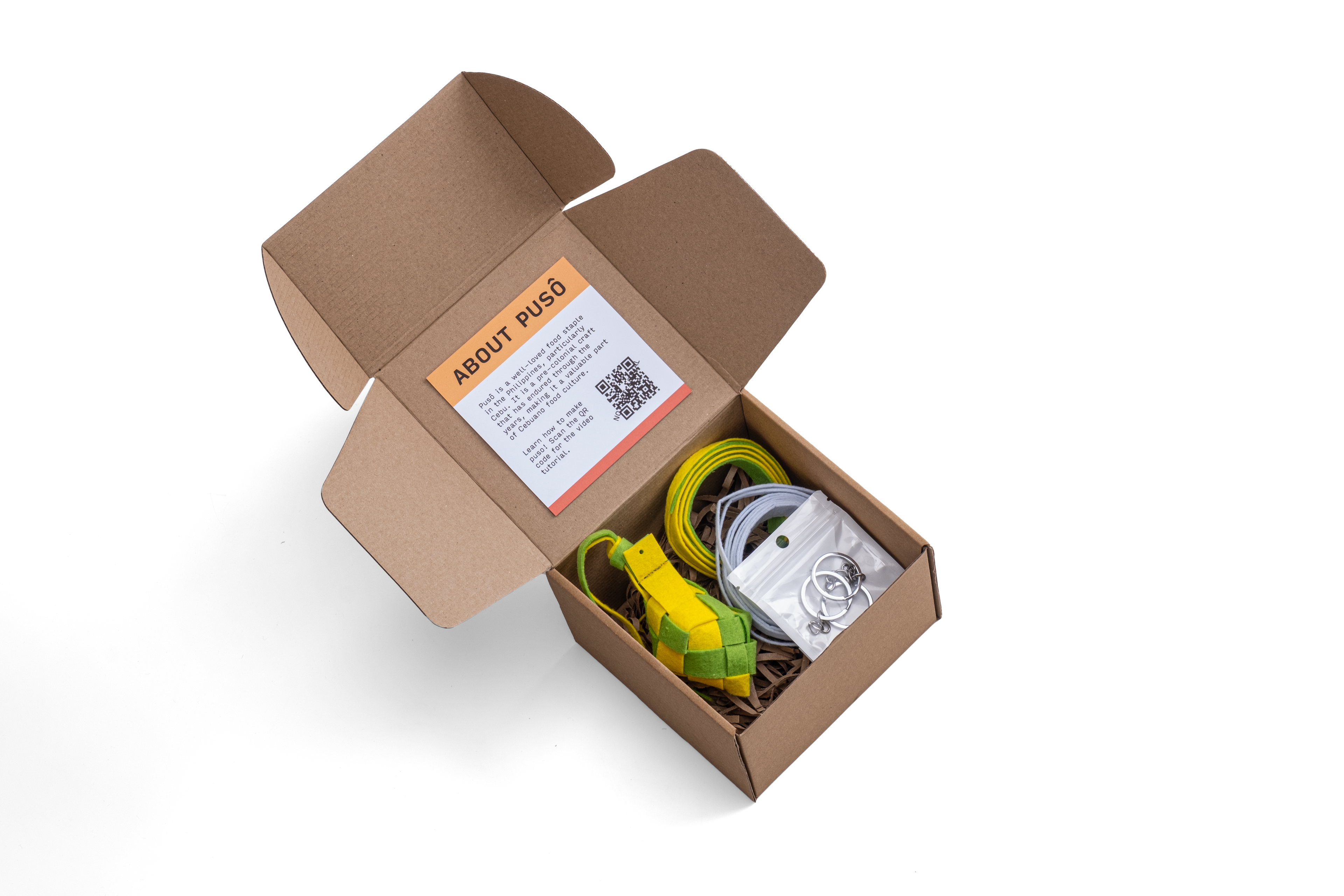 A photo of the Making Things Puso Making Kit inclusions inside its packaging. The kit includes 1 woven puso, 2 puso strips, 3 key rings, and a video tutorial.