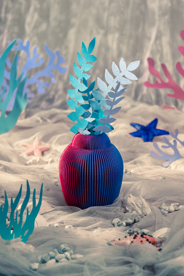 A 3D-printed iridescent vase with paper plants