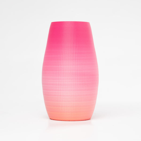 A 3D-printed vase that uses a multi-colored filament that creates a pink to light orange gradient.